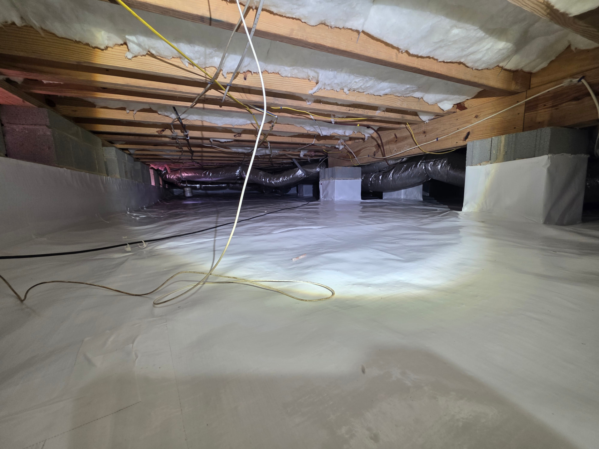 ETA crawlspace project with white floor liner and wrapped foundation piers